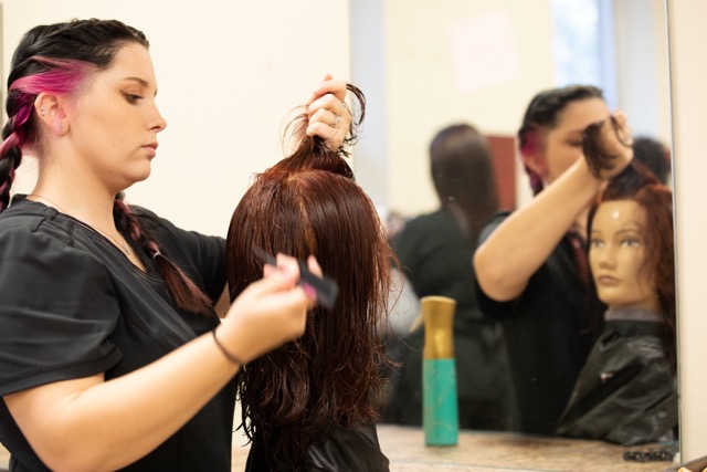 Cosmetology student cutting hair